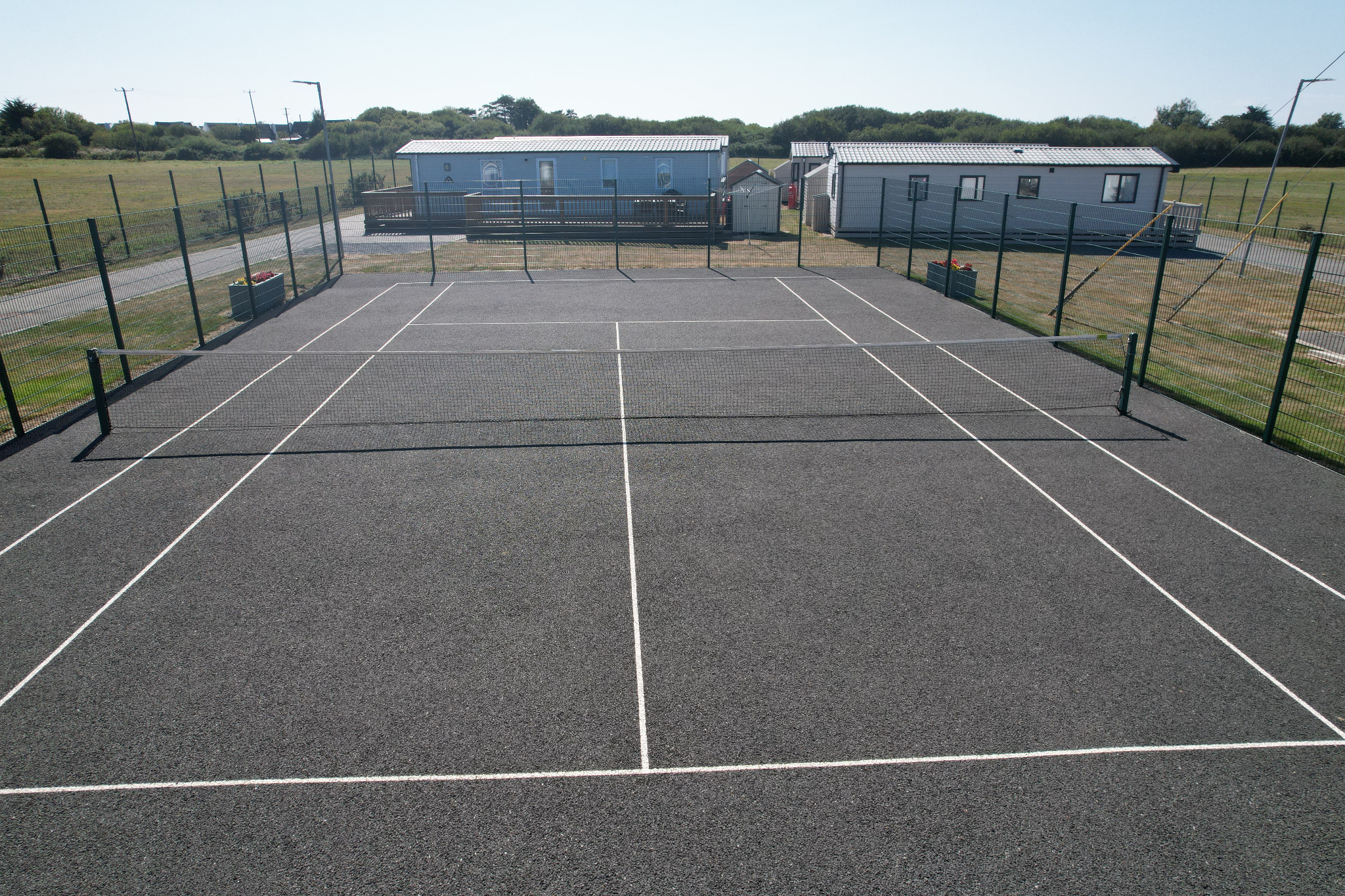 Tennis court at Central Holiday Park Rosslare with a net and surrounding fencing